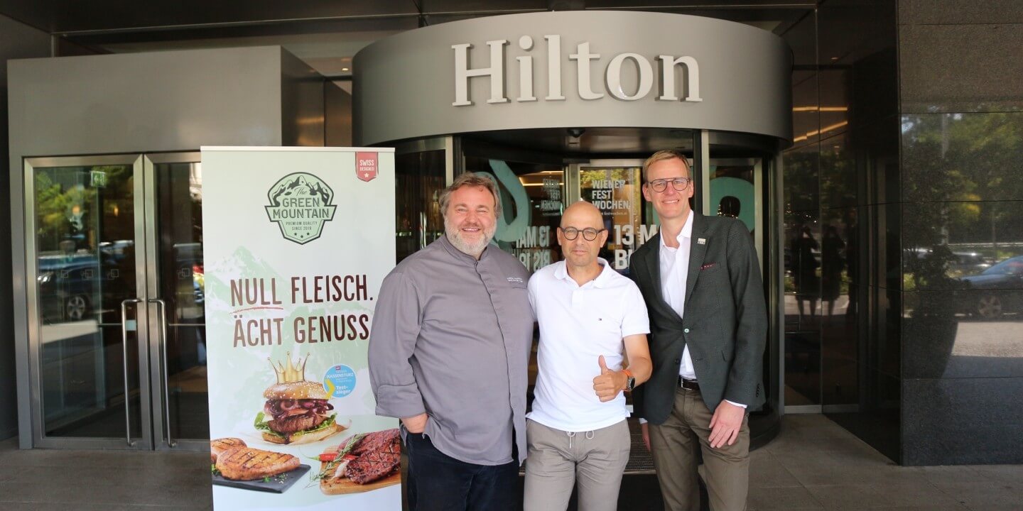 Drei Männer stehen vor dem Hilton Hotel, Three men stand in front of the Hilton Hotel, Trois hommes se tiennent devant l'hôtel Hilton