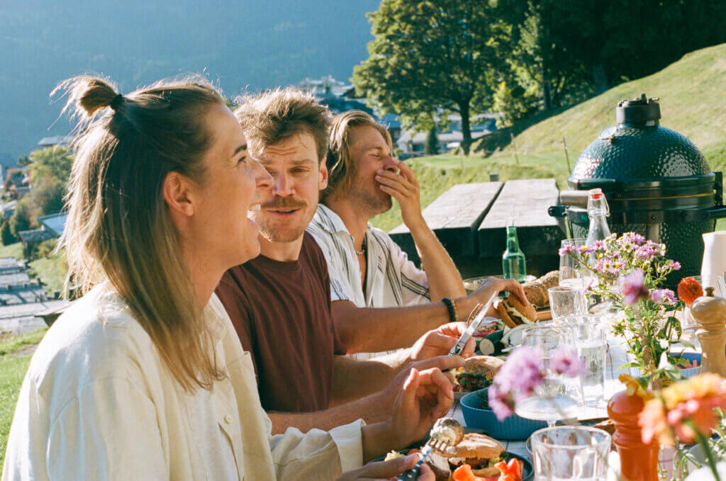Freunde am Tisch beim Grillen.